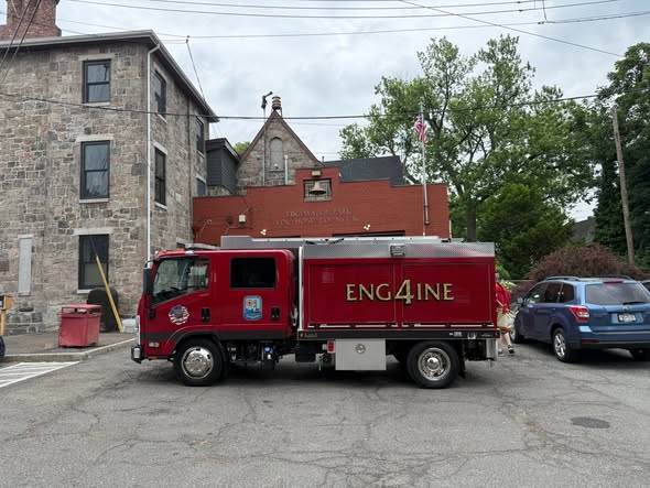 Red Edgewater Park Engine 4 parked in profile outside its firehouse.